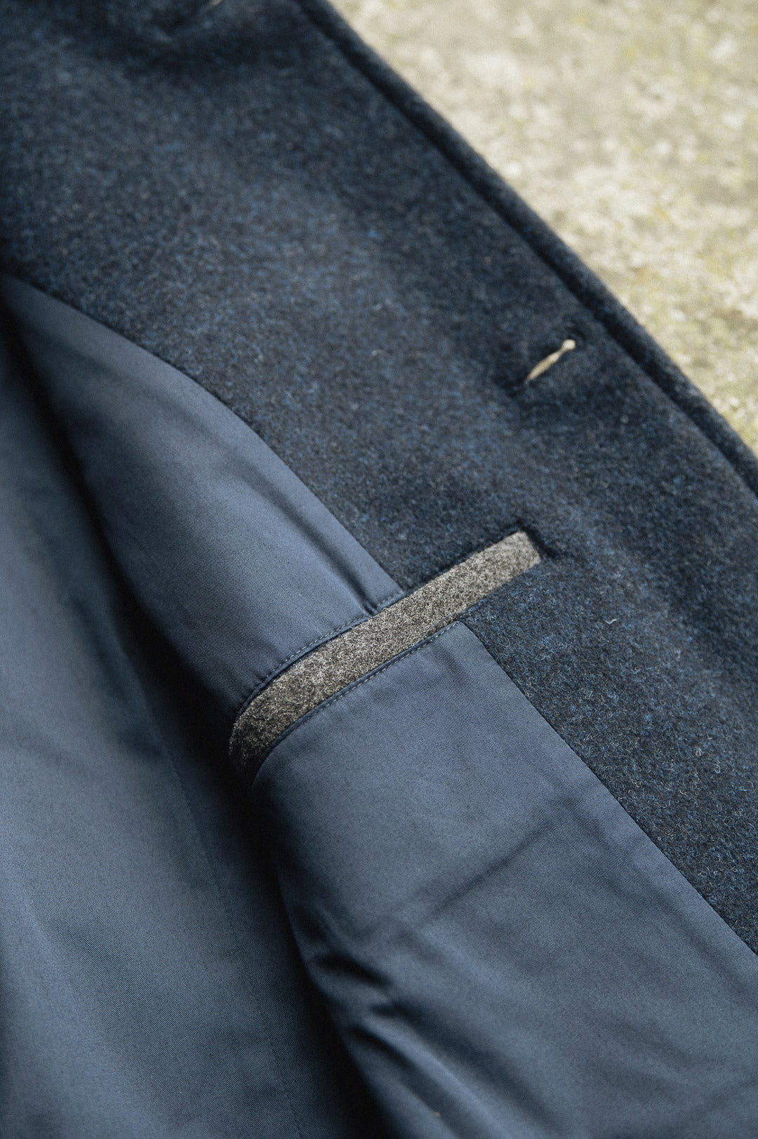 Close-up of a Darzi Midnight Blue merino wool waistcoat - top pocket detail with contrast pocket welt in charcoal grey