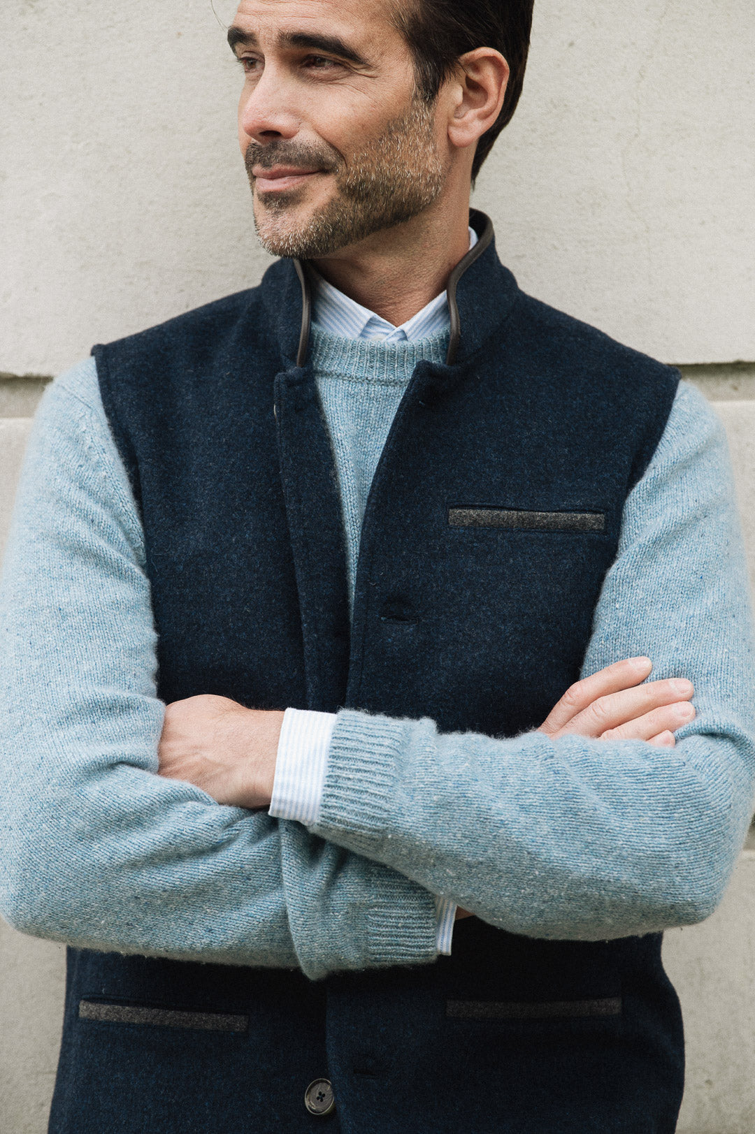 Man wearing a Darzi Midnight Blue merino wool waistcoat over a light blue jumper, set against a neutral background