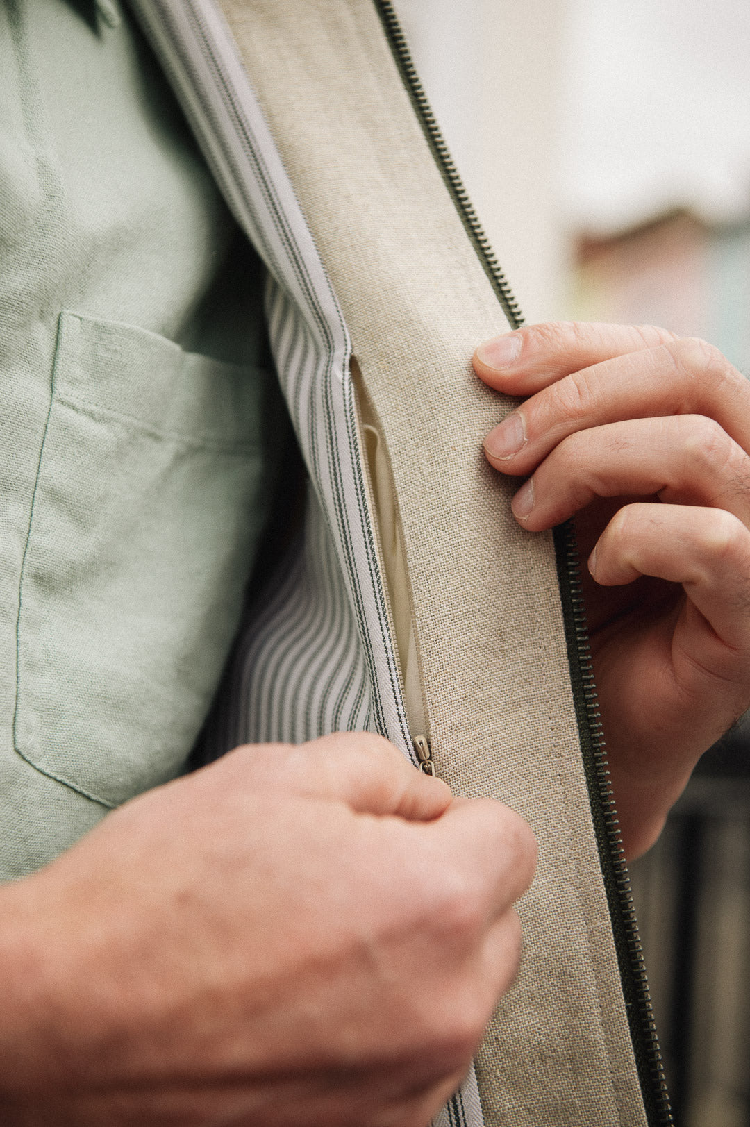 Close-up of a person wearing Darzi limestone linen Hillgate gilet showing close-up of concealed inside pocket