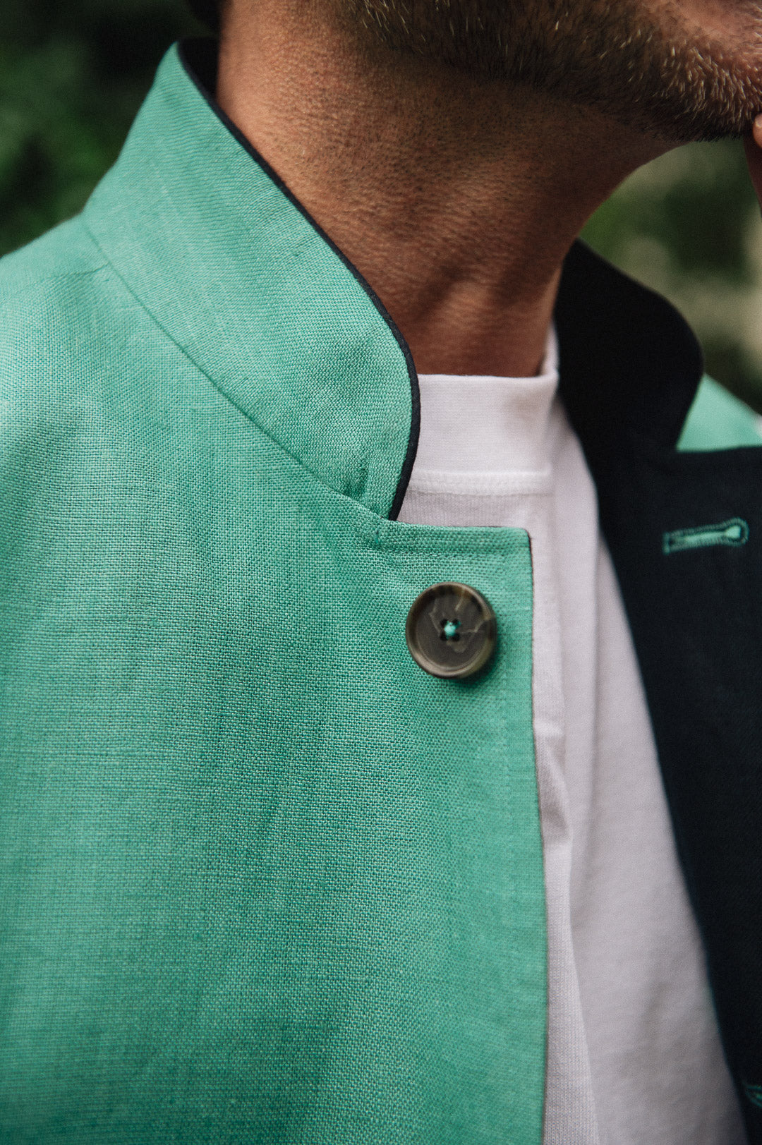 Close-up of a Darzi Como waistcoat in jade green with navy contrast lining