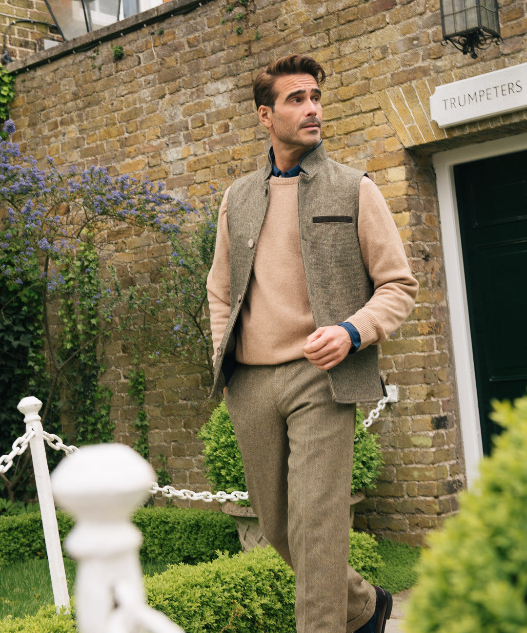 Darzi Helmsley Houndstooth gilet worn by man in front of brick surround door