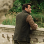 Man wearing a Darzi Helmsley green brown twill wool waistcoat, shown from behind