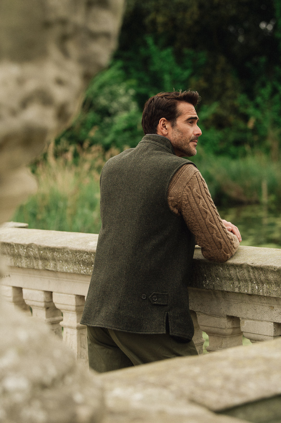 Man wearing a Darzi Helmsley green brown twill wool waistcoat, shown from behind