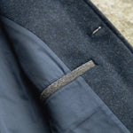 Close-up of a Darzi Midnight Blue merino wool waistcoat - top pocket detail with contrast pocket welt in charcoal grey