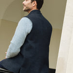 Man wearing a Darzi Midnight Blue merino wool waistcoat, sitting on a black railing - back detail