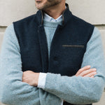 Man wearing a Darzi Midnight Blue merino wool waistcoat over a light blue jumper, set against a neutral background
