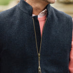 Man wearing a Darzi Hillgate heavyweight midnight blue merino wool gilet over a pink sweater - double brass zip close-up