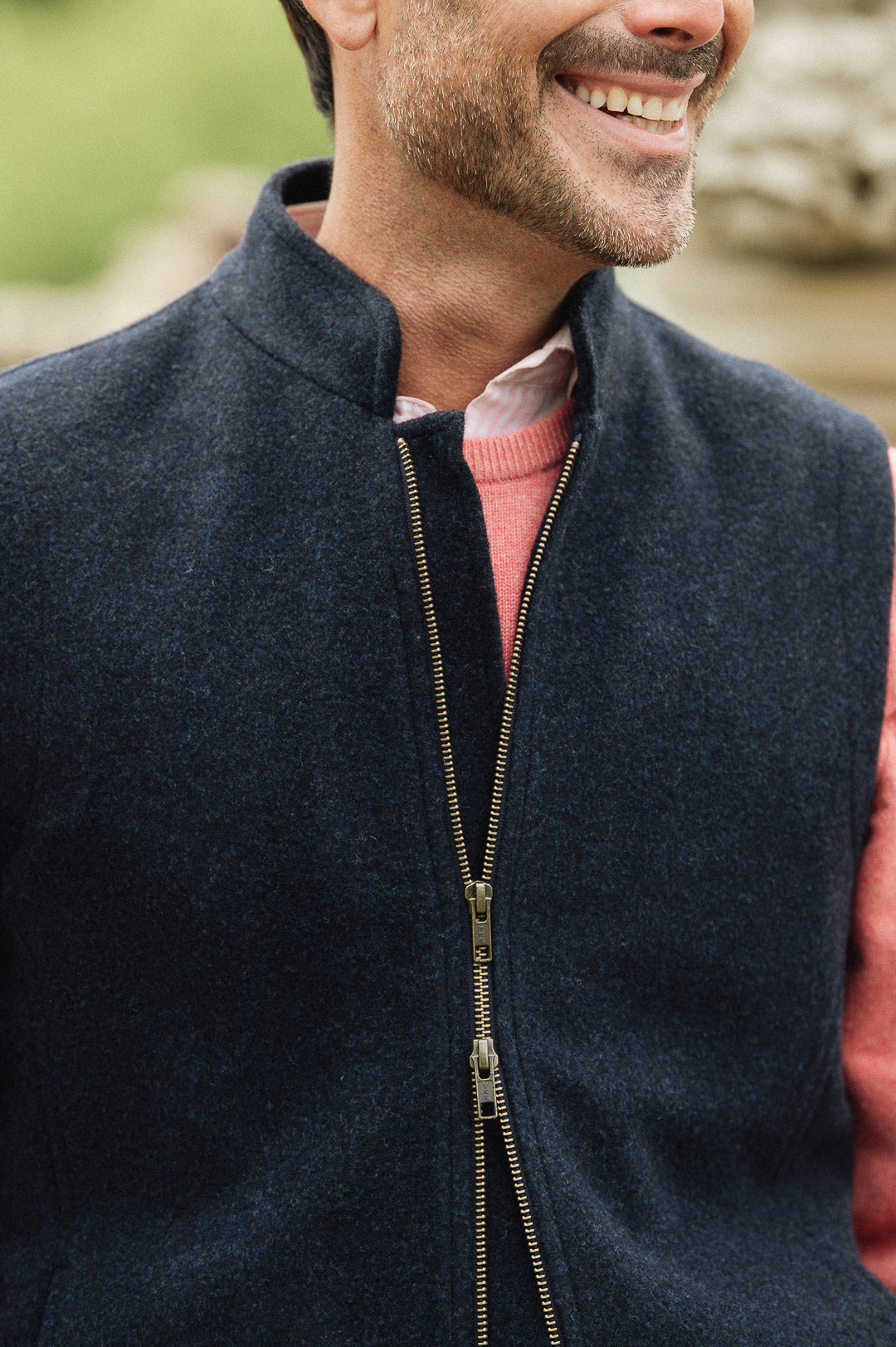 Man wearing a Darzi Hillgate heavyweight midnight blue merino wool gilet over a pink sweater - double brass zip close-up