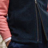 Man wearing a Darzi Hillgate heavyweight midnight blue merino wool gilet over a pink sweater - double brass zip close-up