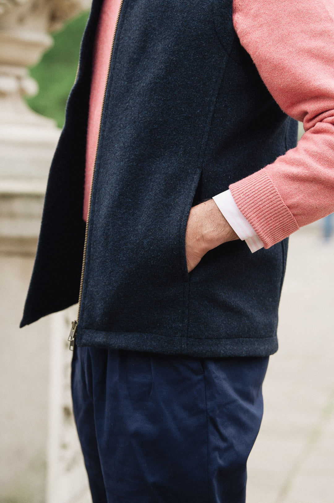 Man wearing a Darzi Hillgate heavyweight midnight blue merino wool gilet over a pink sweater - side pocket close-up