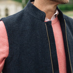 Man wearing a Darzi Hillgate heavyweight midnight blue merino wool gilet over a pink sweater