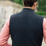 Man wearing a Darzi Hillgate heavyweight midnight blue merino wool gilet over a pink sweater - shown from behind