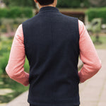 Man wearing a Darzi Hillgate heavyweight midnight blue merino wool gilet over a pink sweater - shown from behind