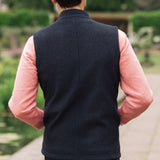 Man wearing a Darzi Hillgate heavyweight midnight blue merino wool gilet over a pink sweater - shown from behind