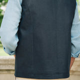 Person wearing a Darzi navy linen Hillgate gilet over a light blue shirt with beige pants, standing outdoors.
