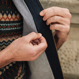 Person wearing a patterned sweater and Darzi navy linen Hillgate vest, showing concealed inside breast pocket opening