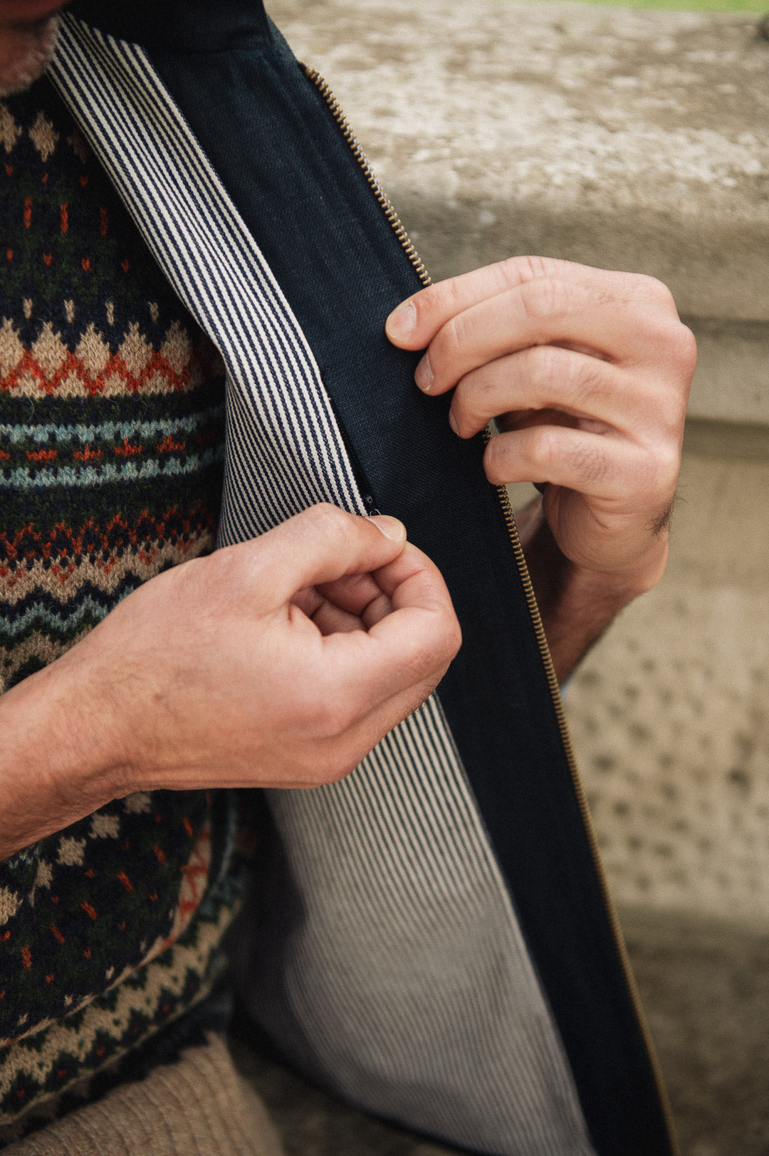 Person wearing a patterned sweater and Darzi navy linen Hillgate vest, showing concealed inside breast pocket opening