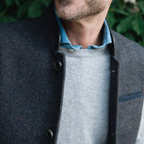 Man standing outdoors wearing a Darzi Helmsley wool waistcoat in Blue Brown Twill over a grey sweater