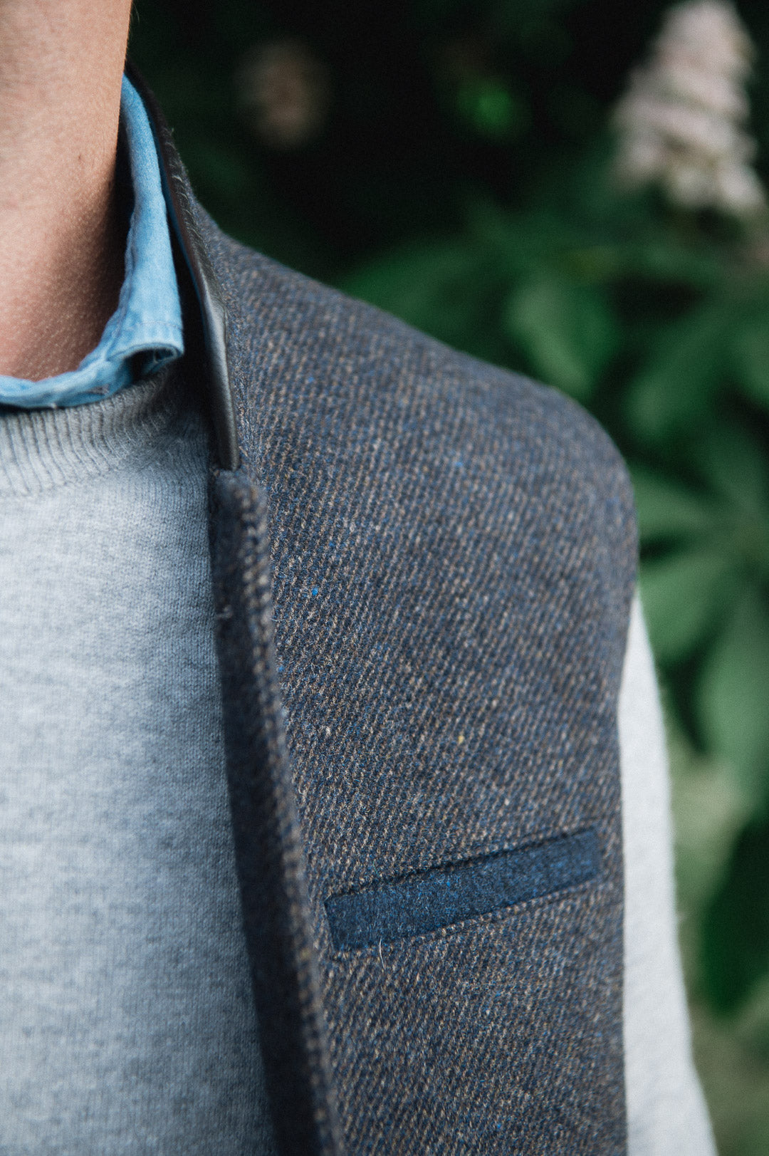 Man wearing a Darzi Helmsley wool waistcoat in Blue Brown Twill over a grey sweater and blue collared shirt