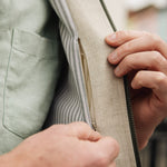 Close-up of a person wearing Darzi limestone linen Hillgate gilet showing close-up of concealed inside pocket
