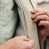 Close-up of a person wearing Darzi limestone linen Hillgate gilet showing close-up of concealed inside pocket