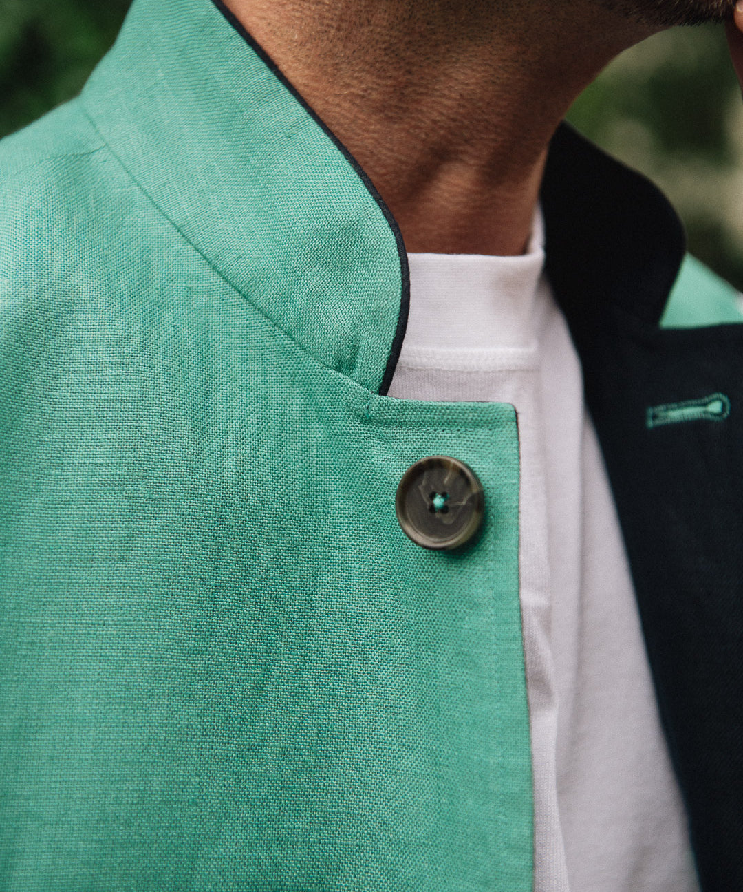 Close-up of a Darzi Como waistcoat in jade green with navy contrast lining