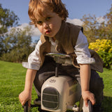 Little boy sitting on toy car wearing a Little Darzi Camel Brown wool waistcoat