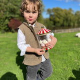 Boy wearing Little Darzi gilet in Camel Brown holding candy jar