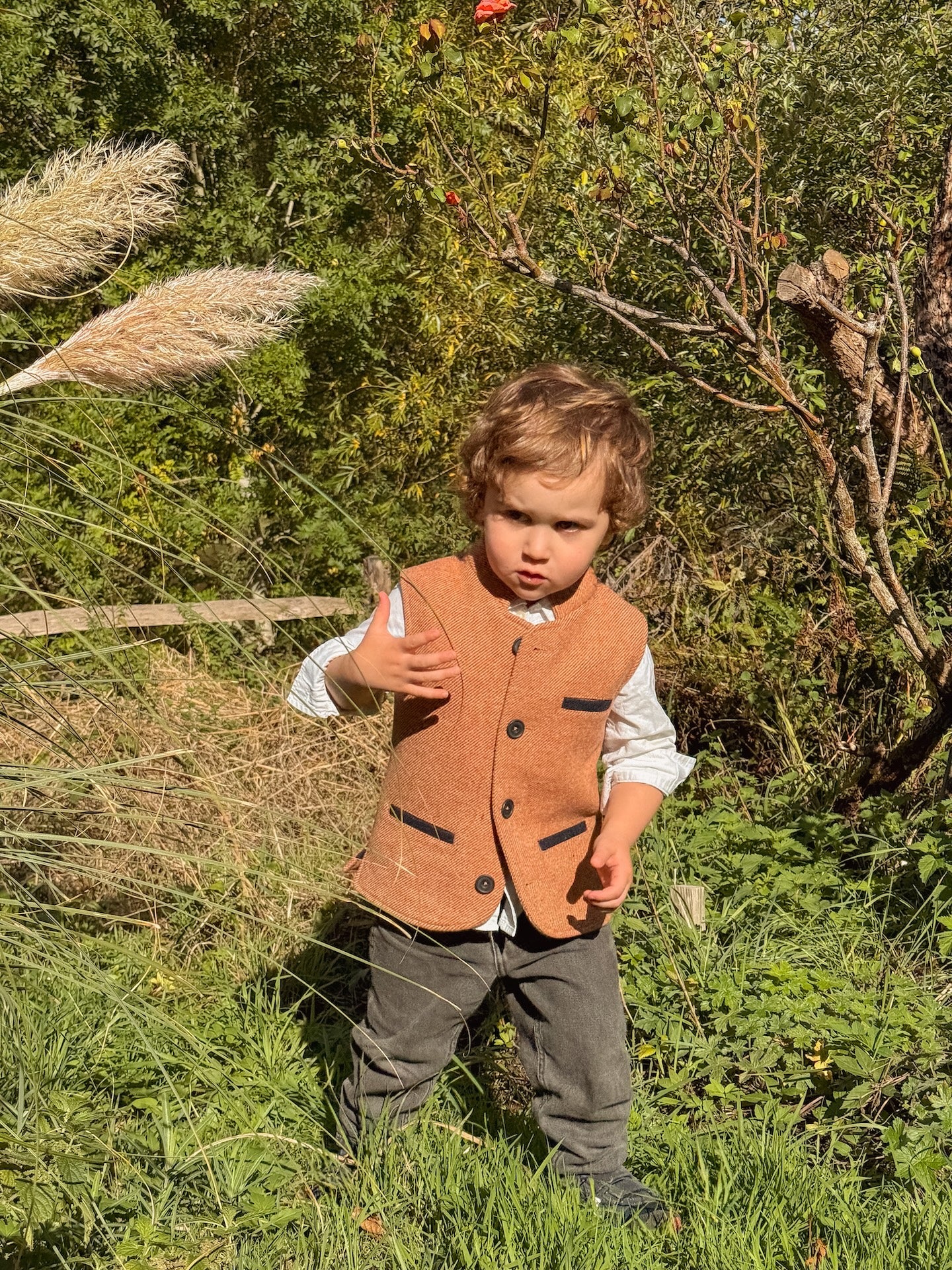Little boy wearing a Coral Red Little Darzi wool waistcoat